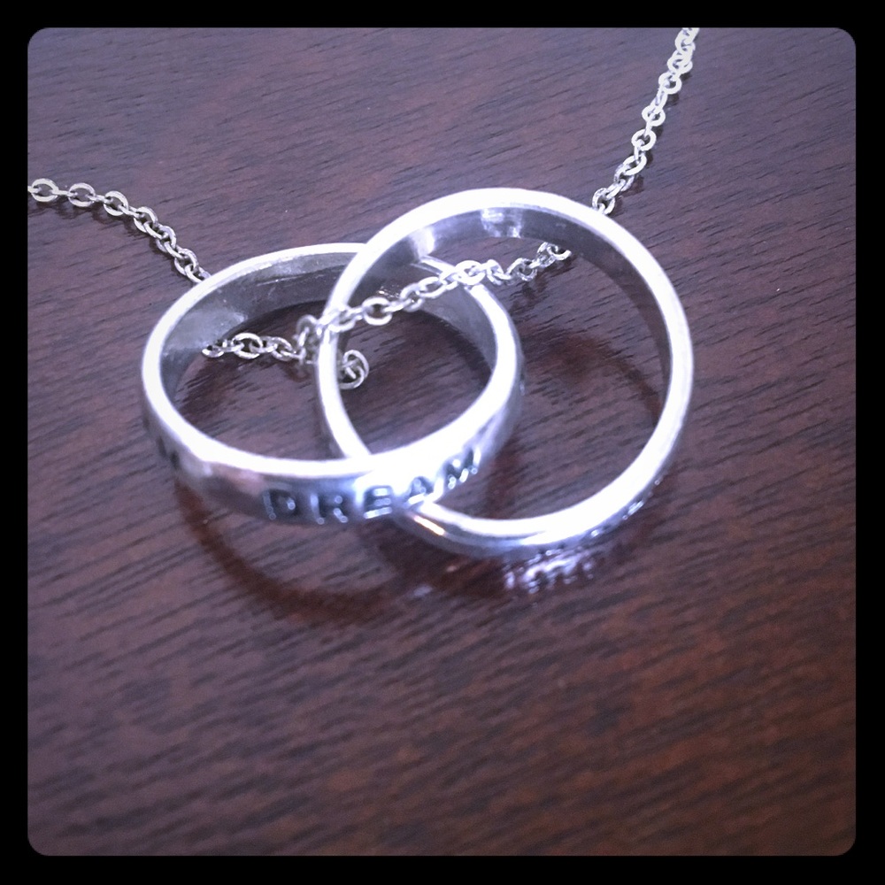 Silver necklace with rings hanging.